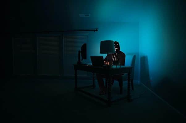 a person sitting at a desk in the dark