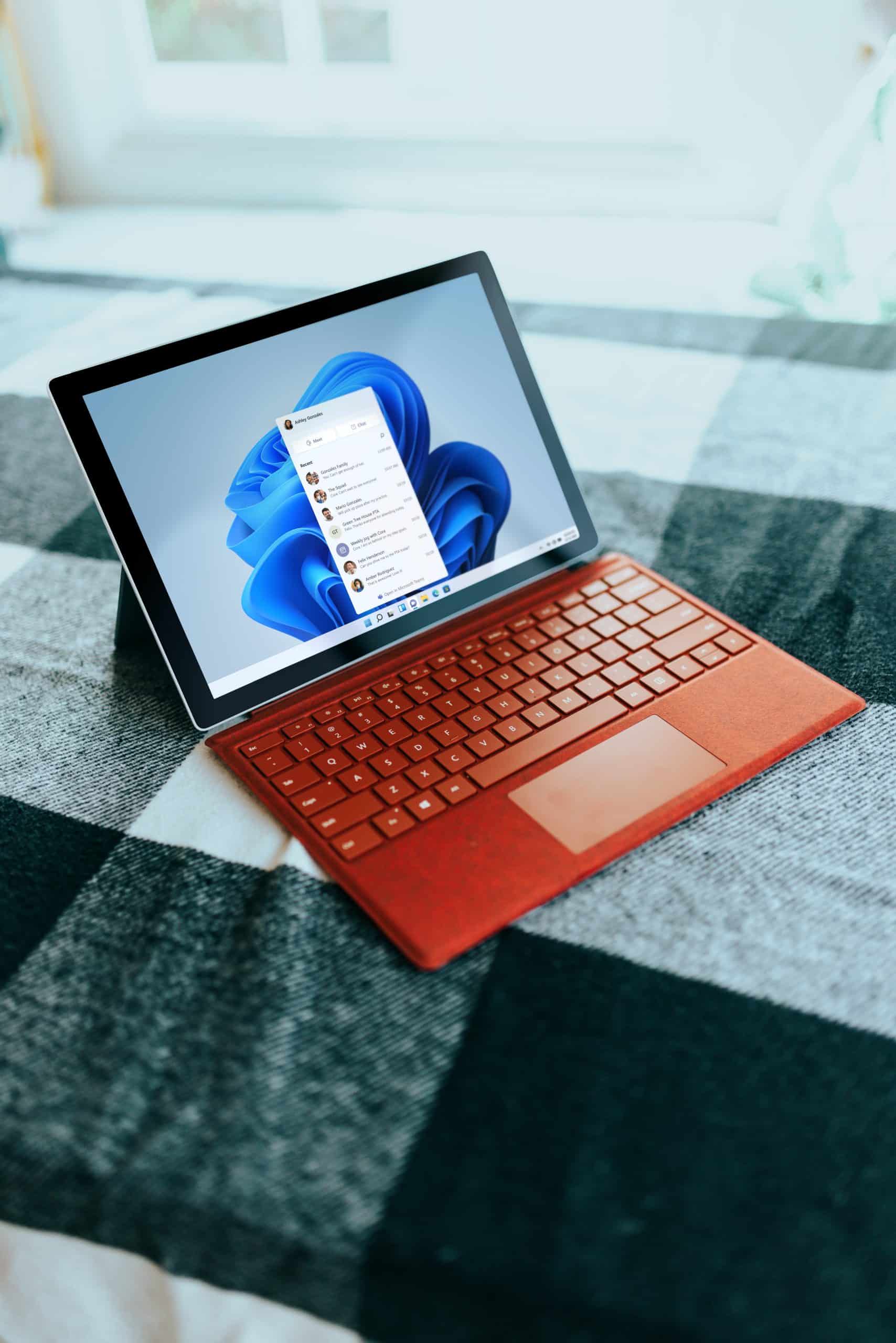 an orange laptop computer sitting on top of a checkered table