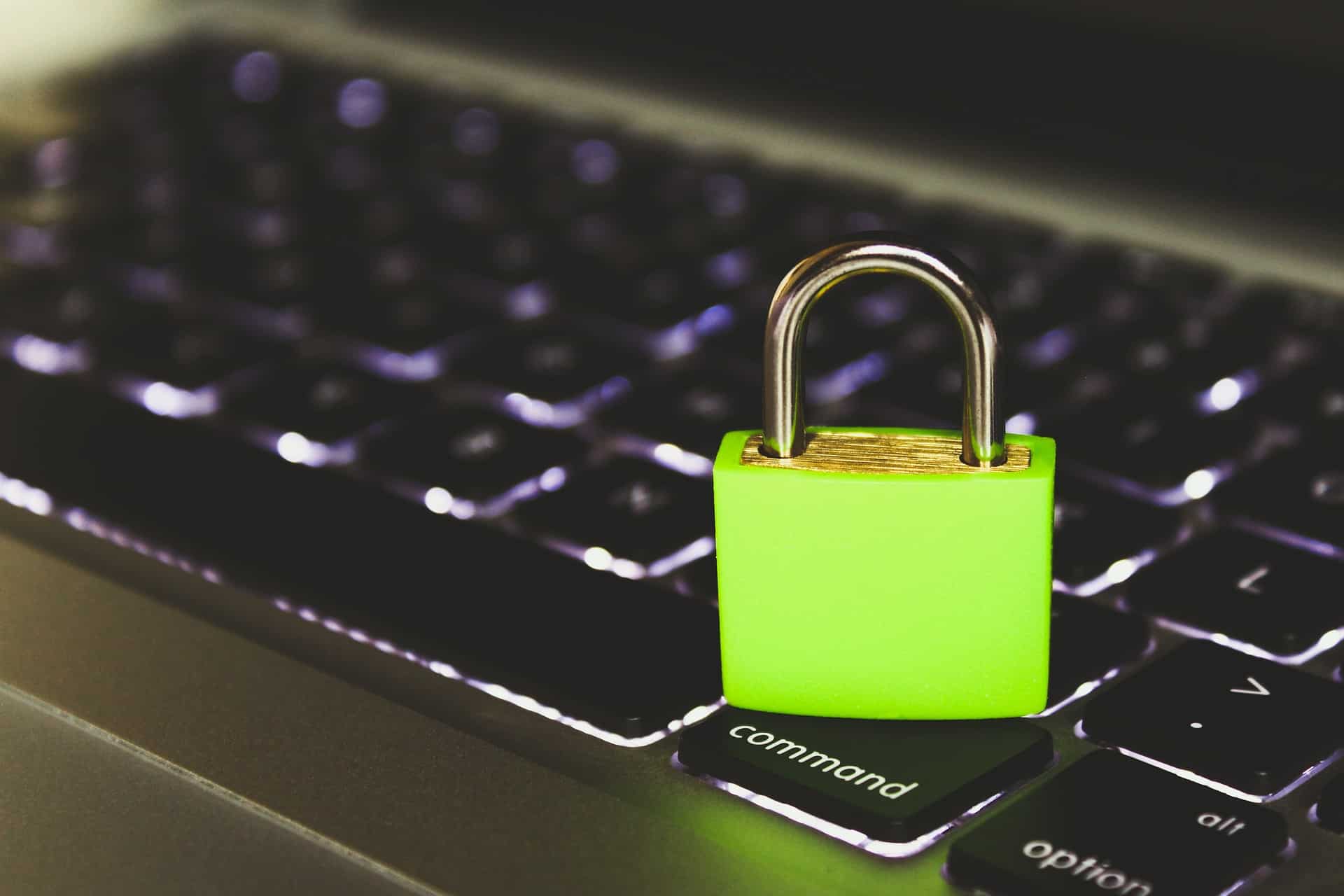 a green padlock sitting on top of a computer keyboard