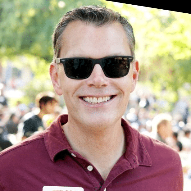 a man wearing sunglasses is smiling for the camera